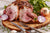 Gammon and onions sitting on a wooden platter.